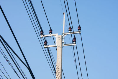 Low angle view of cables against clear blue sky