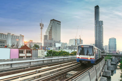 Railroad tracks in city against sky