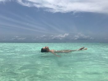 Man in sea against sky