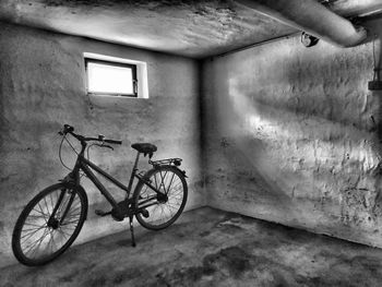 Bicycle parked against wall in old building