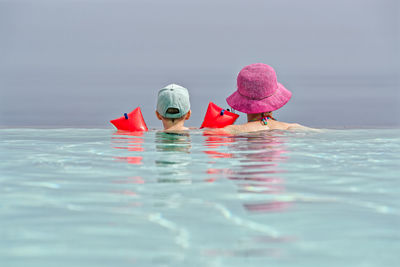 Rear view of woman swimming in sea
