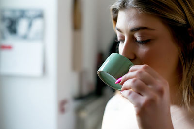 Portrait of woman drinking coffee cup at home