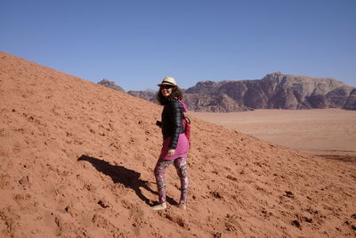 Full length of woman standing at desert