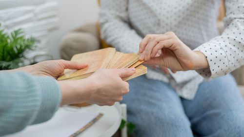 Midsection of man holding cards