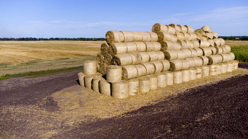 Hay bales on field against sky