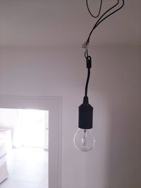 Low angle view of illuminated light bulbs hanging from ceiling