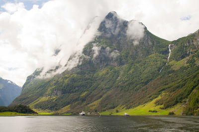 Scenic view of lake by mountains against sky