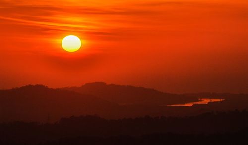 Scenic view of silhouette mountains against romantic sky at sunset