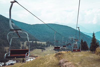 Overhead cable car over mountains against sky