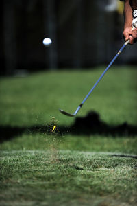 Cropped hands of man playing golf on course