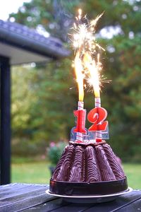 Chocolate cake with illuminated candles on table