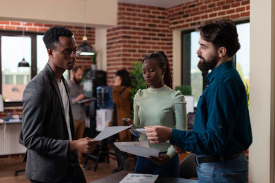 Business colleagues discussing over document in office