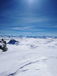 Scenic view of snow mountains against blue sky