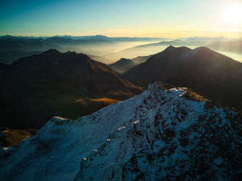 Scenic view of snowcapped mountains against sky during sunset