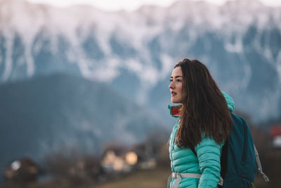 Young woman standing against mountain