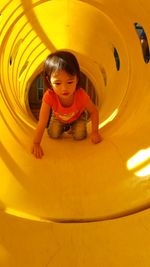 Cute girl playing in tunnel at playground