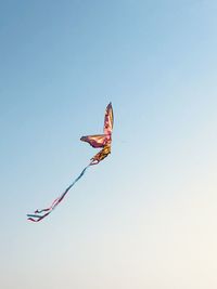 Low angle view of kites flying against clear sky