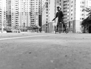 Man riding bicycle on street against buildings in city