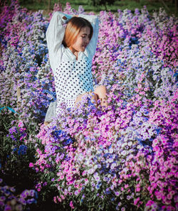 Full length of woman standing on purple flowering plants
