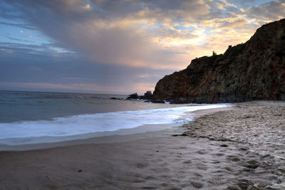 Scenic view of beach against sky during sunset