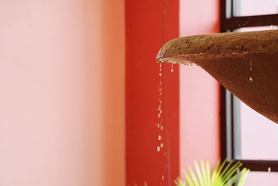 Water dripping from container against wall