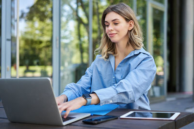 Young businesswoman using laptop at office