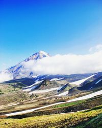 Scenic view of mountains against blue sky