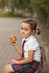 Portrait of cute girl sitting in park