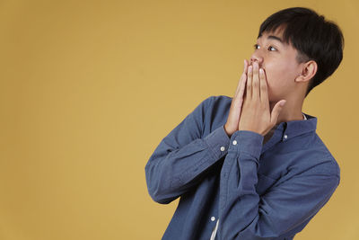 Portrait of mid adult man against yellow background