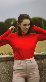 Midsection of woman with red hair standing against blurred background