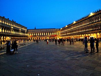 Tourists in front of building against clear sky