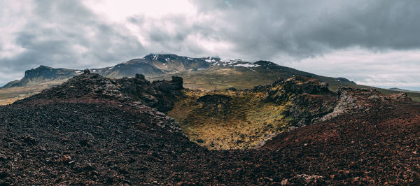 Scenic view of mountains against cloudy sky