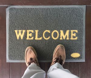 Low section of man standing on doormat