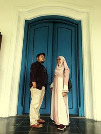 Couple standing by door of building