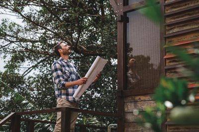 Low angle view of man standing by tree