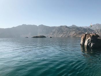 Scenic view of sea and mountains against clear sky