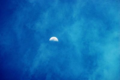 Low angle view of moon against blue sky