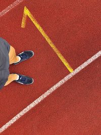 Low section of man standing on sports track