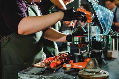 Midsection of chefs preparing food in cafe