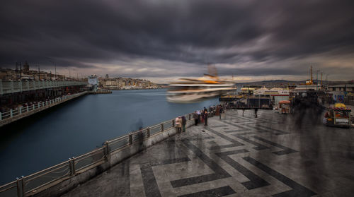 Bridge over river against cloudy sky