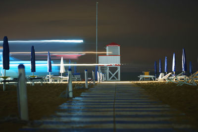 Pier over sea against sky at night