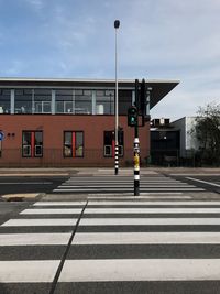 Zebra crossing on road against buildings