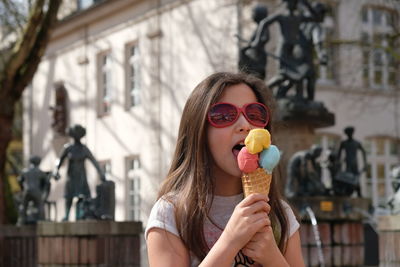 Midsection of woman holding ice cream in city