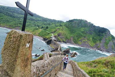 People walking on mountain road against sky