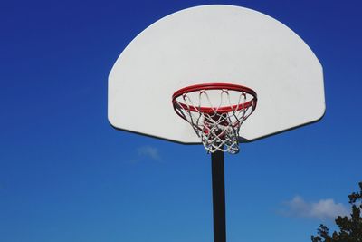 Low angle view of basketball hoop against clear blue sky