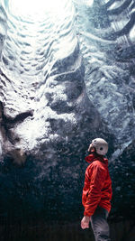 Rear view of man standing in ice cave