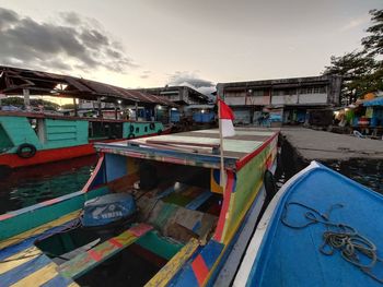 Fishing boat in lake against sky in city