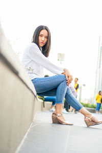 Portrait of smiling young woman sitting outdoors