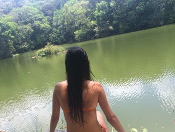 Rear view of woman in lake against trees