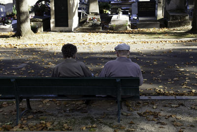 Rear view of people sitting on bench